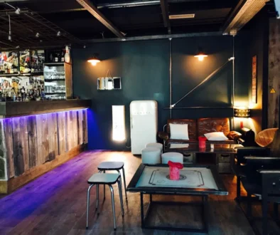 Intérieur de bar lounge tamisé avec comptoir, assises et tables basses, pour illustrer un cadre d’afterwork.