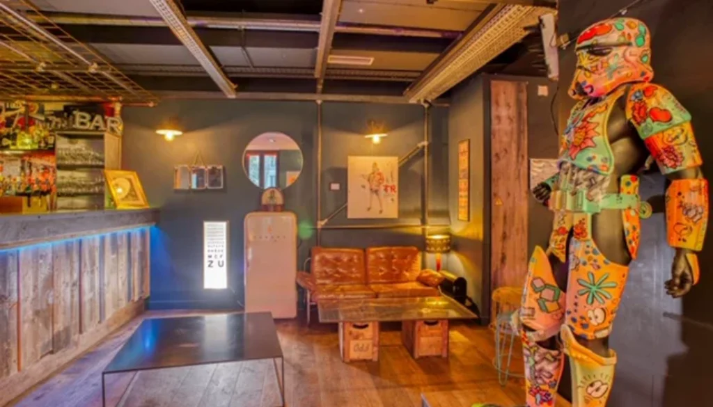 Espace intérieur avec un long bar, un canapé et une sculpture multicolore