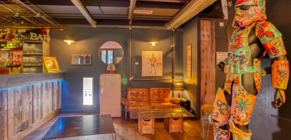 Espace intérieur avec un long bar, un canapé et une sculpture multicolore