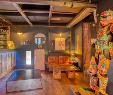 Espace intérieur avec un long bar, un canapé et une sculpture multicolore