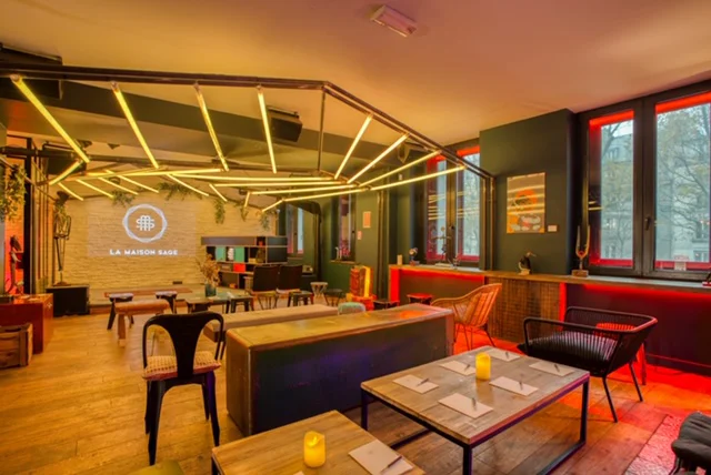 Salle de restauration avec tables, chaises, comptoir central et éclairage chaleureux, en exemple de lieu à évaluer pour un événement.