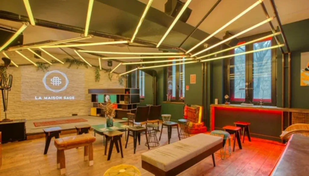 Espace intérieur de type lounge avec tables, assises variées et éclairage chaleureux