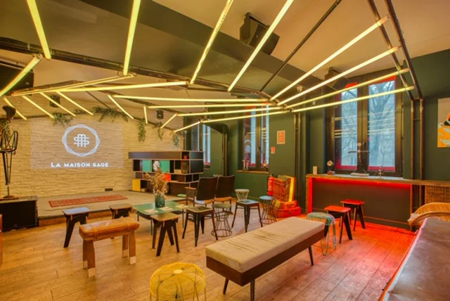 Espace intérieur de type lounge avec tables, assises variées et éclairage chaleureux