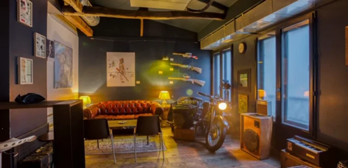 Salle intérieure au style industriel avec assises en cuir, mobilier vintage et moto.