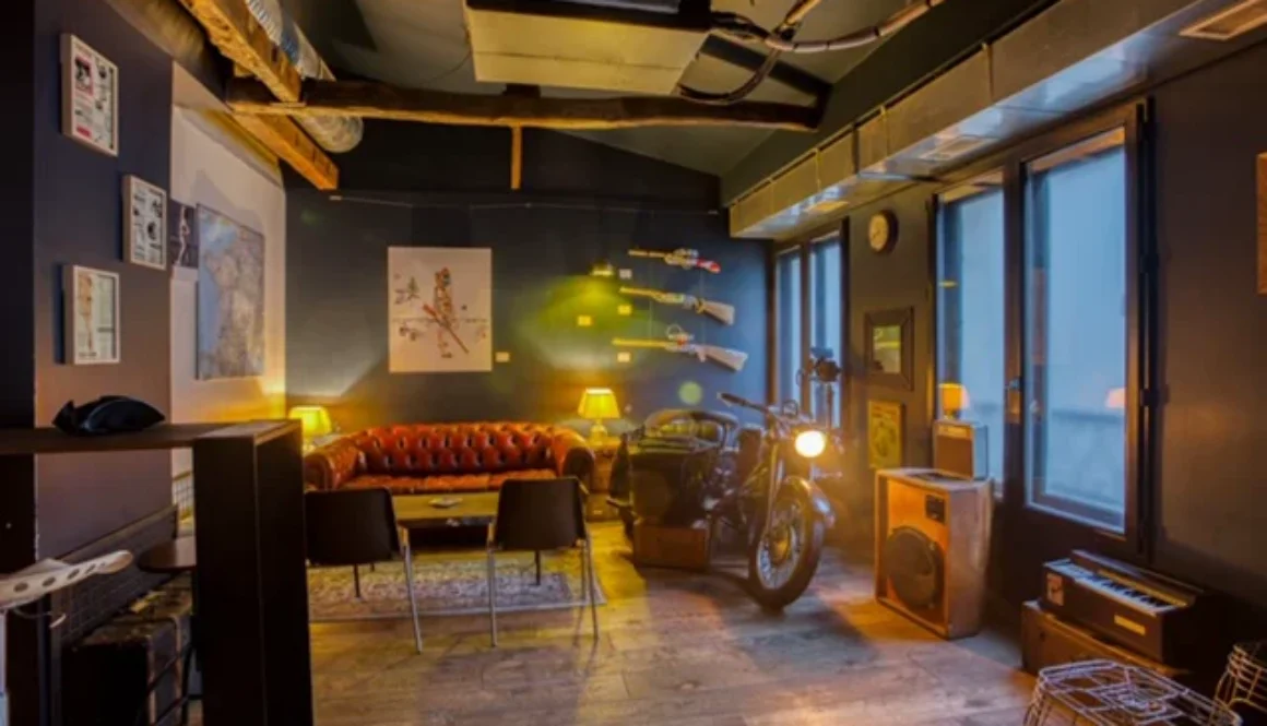 Salle intérieure au style industriel avec assises en cuir, mobilier vintage et moto.