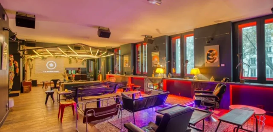Espace lounge intérieur avec canapés, fauteuils, tables et grand écran